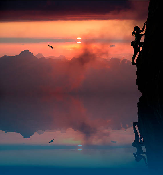 Female rock climber and mountain sunset
