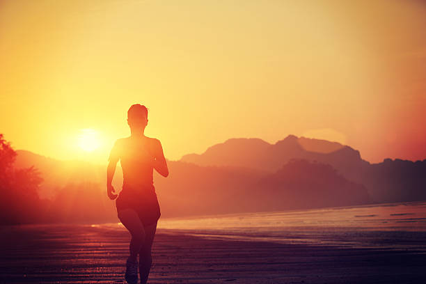 istock young woman running on sunrise beach 465326016
