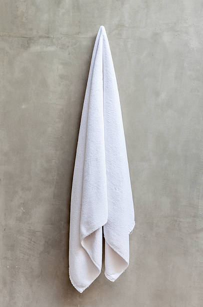 istock White towel is hanging on a hanger with concrete wall 465326344