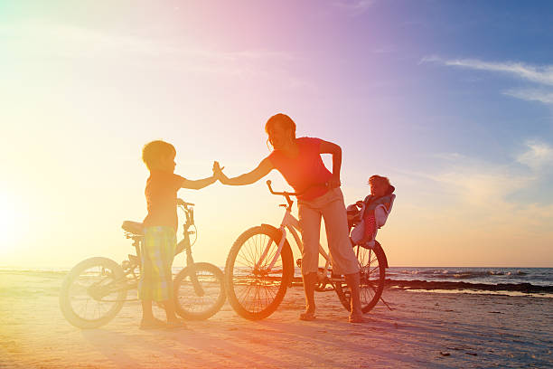 istock mother with kids biking at sunset 465327240