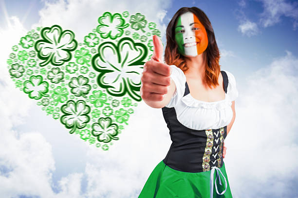 Irish girl showing thumbs up against bright blue sky with clouds