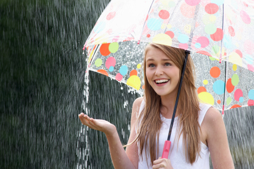 Beautiful girl in the rain with umbrella