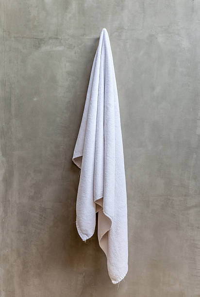istock White towel is hanging on a hanger with concrete wall 465330810