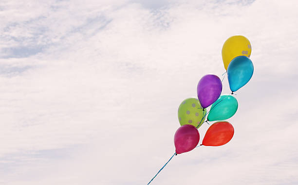 istock Man holding colorful balloons outside 465331384
