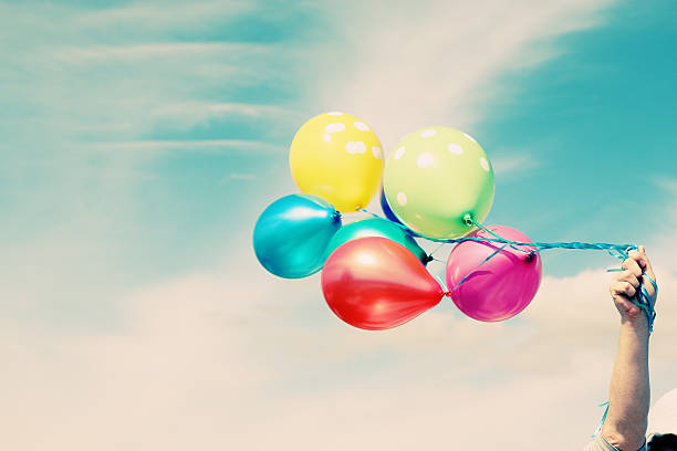 istock Man holding colorful balloons outside 465331406