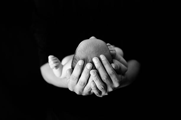 Newborn in Father's Hands stock photo