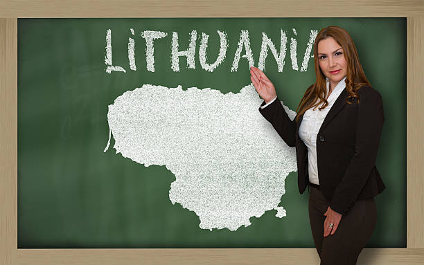 istock Teacher showing map of lithuania on blackboard 465345026