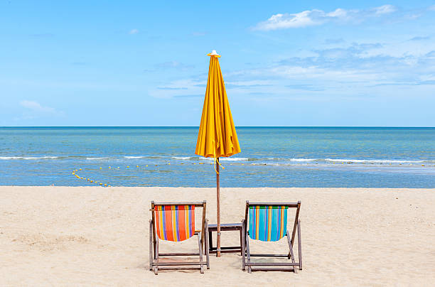 istock Two beach chairs with sun umbrella on beautiful beach. 465345144