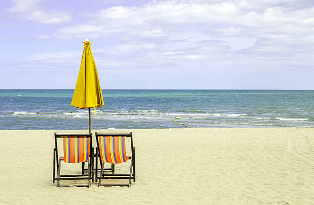 istock Pair of beach chairs with sun umbrella on beautiful beach. 465345154