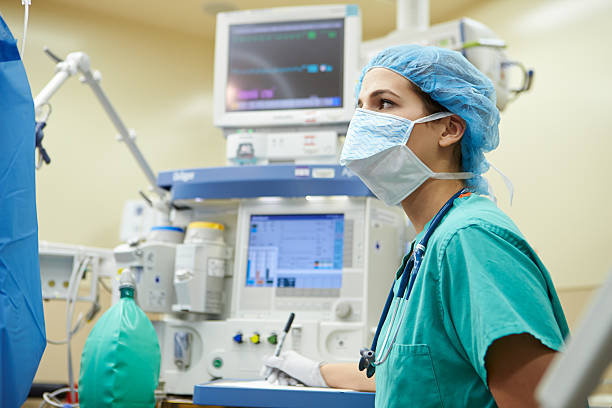 Anesthetist Working In Operating Theatre Anesthetist Working In Operating Theatre Wearing Protecive Gear anaesthetist stock pictures, royalty-free photos & images