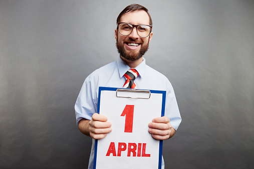 Nerdy office worker showing April fools day date