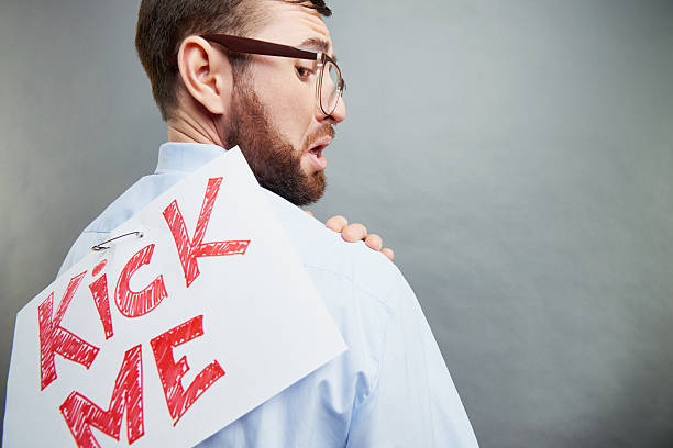 Office worker with kick me sign on his back