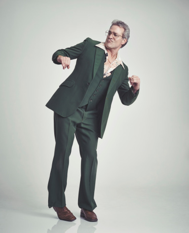 Studio shot of a mature man in a retro suit doing some old school dance moves