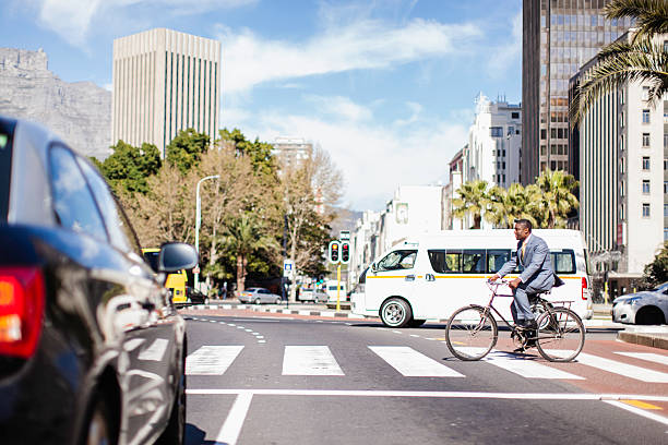 African businessman cycling on Adderley St, Cape Town stock photo