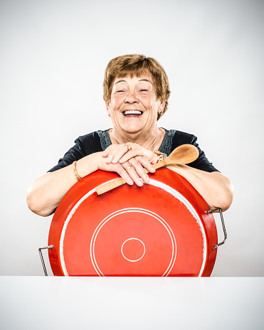 Senior woman holding paella pan