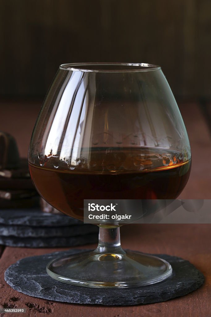 Verre de cognac et chocolat sur la table en bois - Photo de Alcool libre de droits