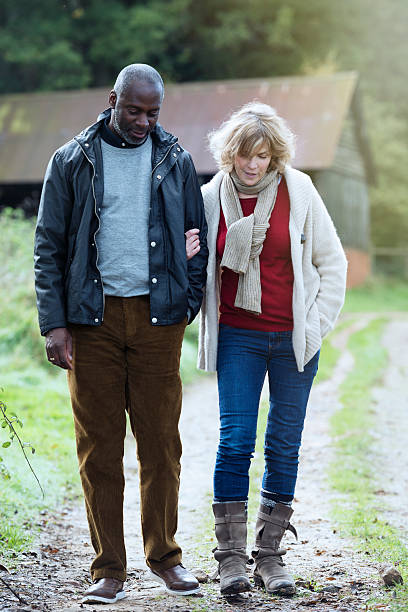 Close up shot of a lesbian couple holding hands and walking along the promenade.