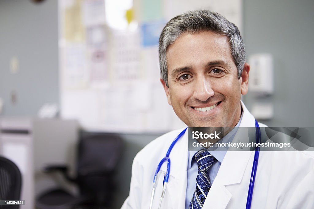 Portrait Of Doctor Working At Nurses Station Portrait Of Doctor Working At Nurses Station Smiling At Camera Doctor Stock Photo