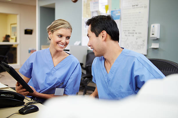 istock Male And Female Nurse Working At Nurses Station 465354577