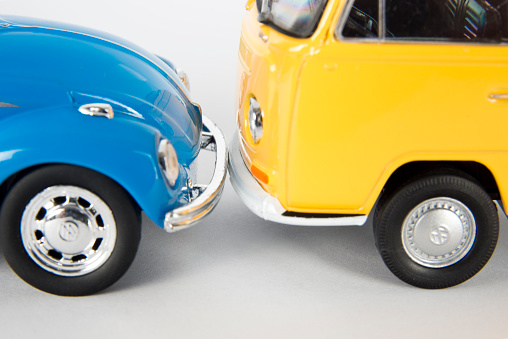 Izmir, Turkey, March 03, 2015: Vintage toy car and toy minibus in front of a white background. The Volkswagen Type 1, widely known as the Volkswagen Beetle, was an economy car produced by the German auto maker Volkswagen (VW) from 1938 until 2003. The Volkswagen Type 2, known officially (depending on body type) as the Transporter, Kombi or Microbus, or, informally, as the Bus (US) or Camper (UK), is a panel van introduced in 1950 by the German automaker Volkswagen as its second car model. 