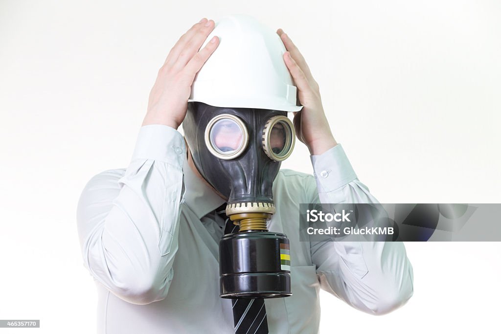 man in helmet and gas mask holding his head, panic man in a helmet and gas mask holding his head, panic 2015 Stock Photo