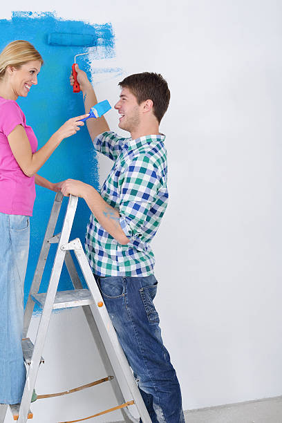 istock happy couple paint wall at new home 465360139