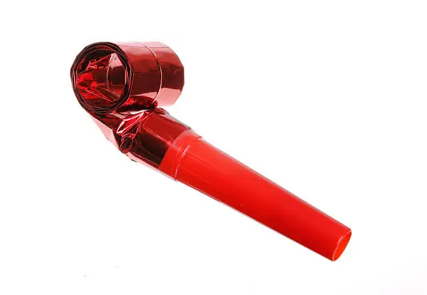 A red colored party whistle isolated on white background.