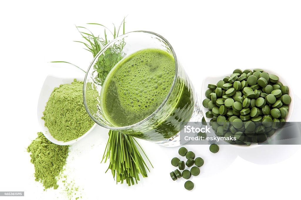 Green superfood. Wheatgrass powder, green chlorella pills and spirulina green juice on white background isolated. Natural healing. Alternative medicine. Alternative Medicine Stock Photo