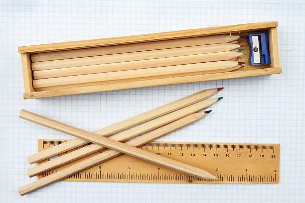Pencils and a pencil case with a rule on graph paper