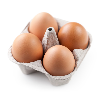 Four brown eggs in carton.