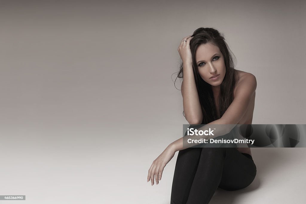 Portrait of sexy brunette Gorgeous young woman posing in studio wearing black leggings. 2015 Stock Photo