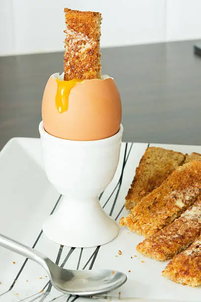 A single boiled egg and toast soldiers.