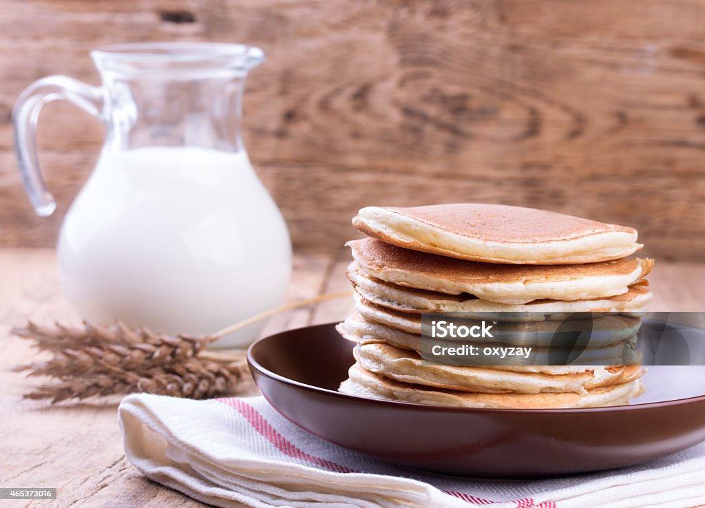 American pancakes with milk American pancakes with jug of milk on wooden background 2015 Stock Photo