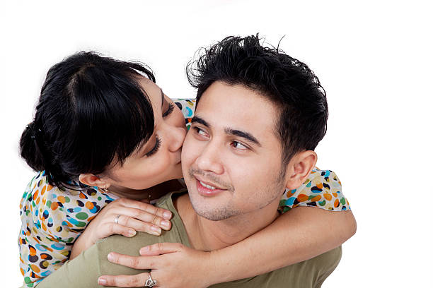 multicultural couple shares a passionate kiss, celebrating their unique connection and shared affection, dressed casually, standing facing each other