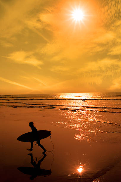 istock silhouette of surfer walking from the sea 465375598