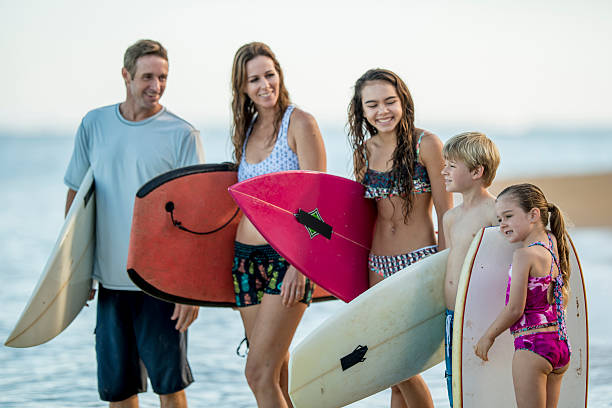 istock Young family posing with surboards on the beach 465376760