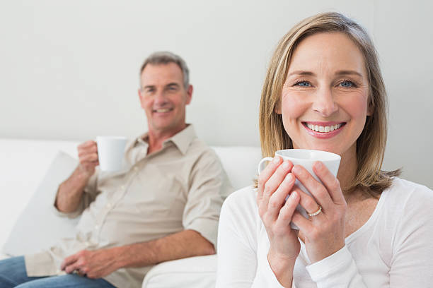 istock Relaxed couple with coffee cups in living room 465381452