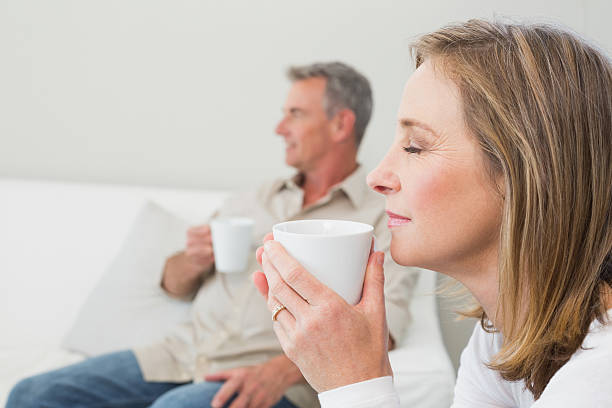 relaxed couple with coffee cups - ogen dicht closeup vrouw 50 jaar stockfoto's en -beelden