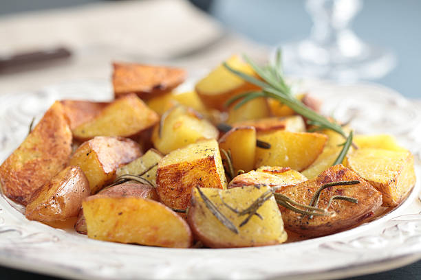 patate arrosto - roasted potatoes prepared potato herb food foto e immagini stock