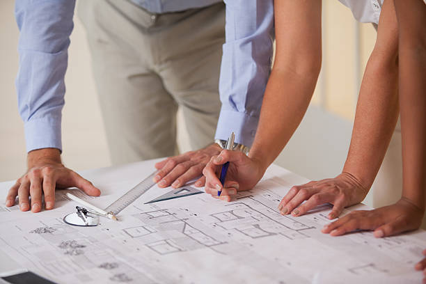 istock Mid section of business people working on blueprints 465382380