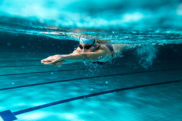 hembra nadador en la piscina. - saltar actividad física fotos fotografías e imágenes de stock