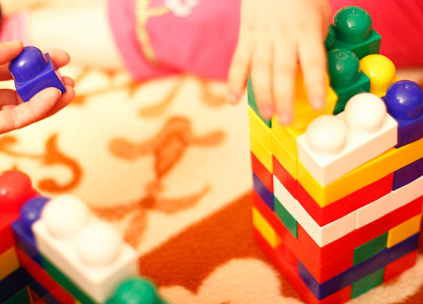 istock Happy girl is playing with toy block. 465383840