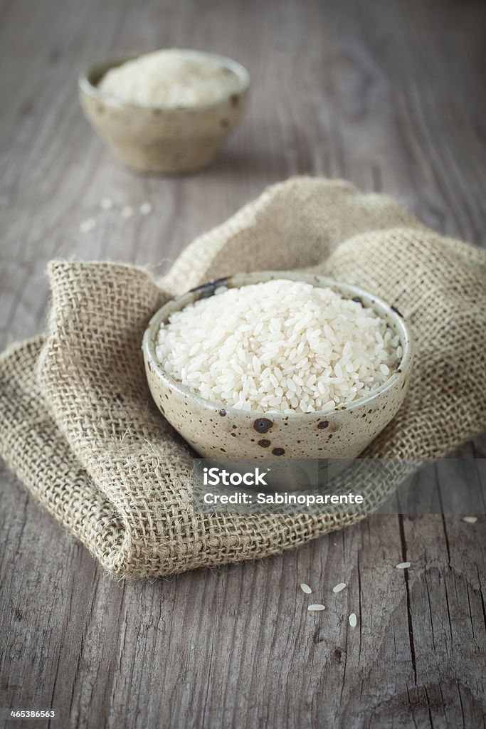 Rice Rice in a bowl on a wooden background Fishbowl Stock Photo