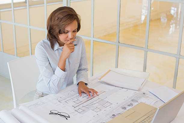 istock Businesswoman working on blueprints in office 465386912