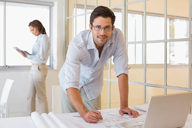istock Businessman working on blueprints with colleague at office 465388054