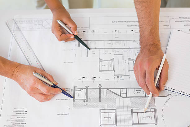 istock Extreme close-up of hands working on blueprints 465388258