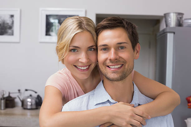 istock Smiling woman embracing man from behind in kitchen 465388502