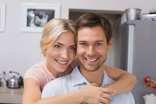 istock Smiling woman embracing man from behind in kitchen 465388506