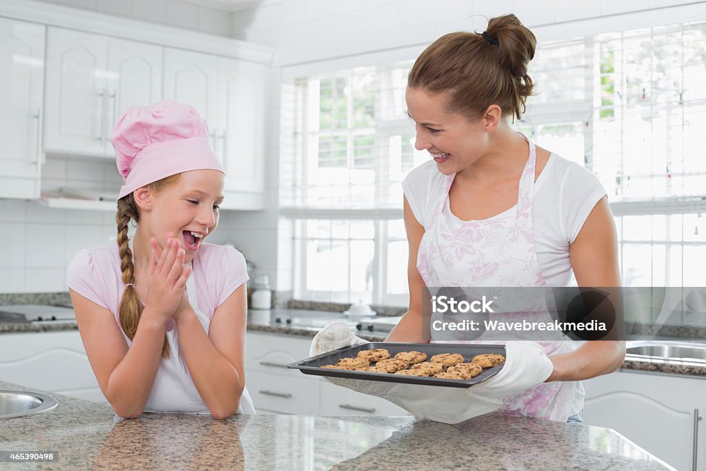 Lächelnde Frau und Mädchen mit frisch zubereitetes Gebäck in der Küche - Lizenzfrei 2015 Stock-Foto