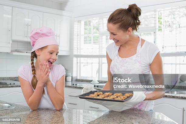 Lächelnde Frau Und Mädchen Mit Frisch Zubereitetes Gebäck In Der Küche Stockfoto und mehr Bilder von 2015